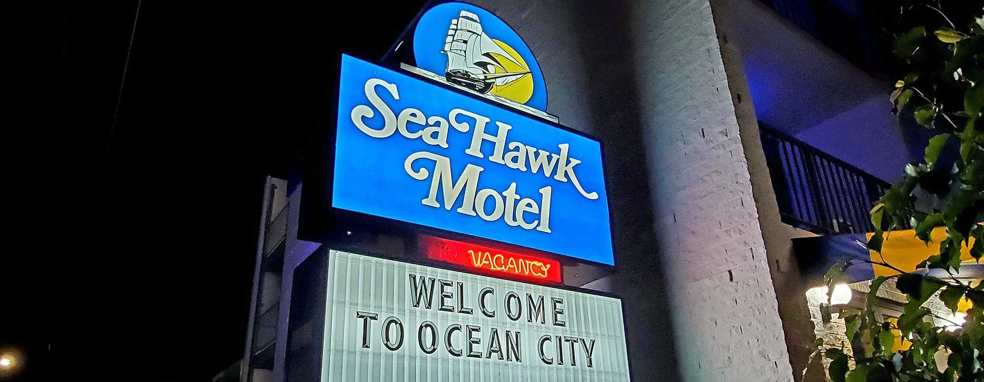 Sea Hawk motel sign lit in the evening